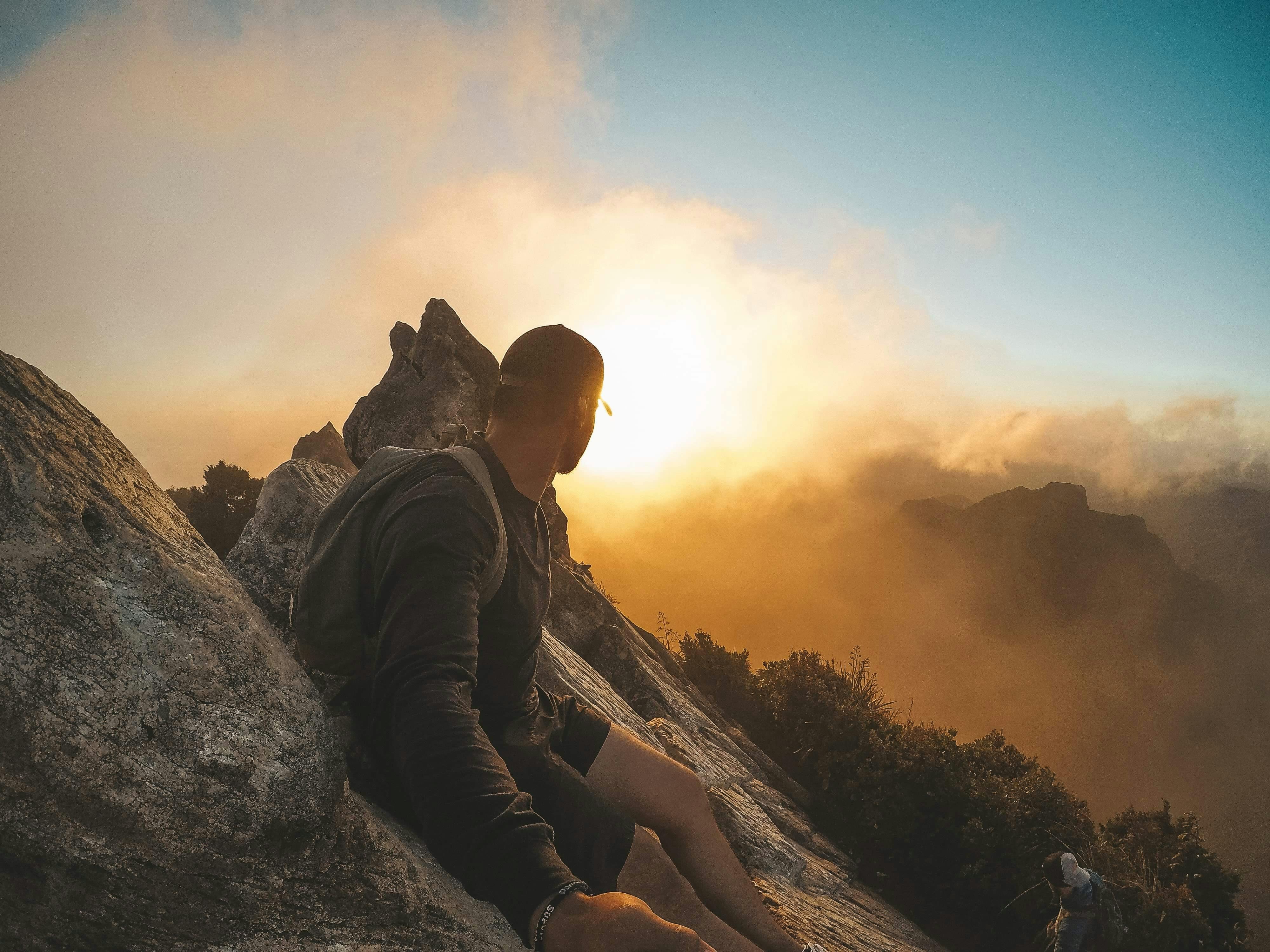 Man enjoying a breathtaking mountain sunset in Waikato, New Zealand, showcasing outdoor adventure and natural beauty.